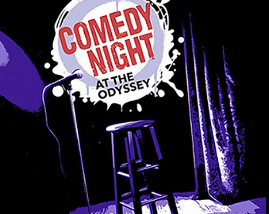 Stage with microphone stand, barstool and spotlight with the words Comedy Night at the Odyssey written on it.