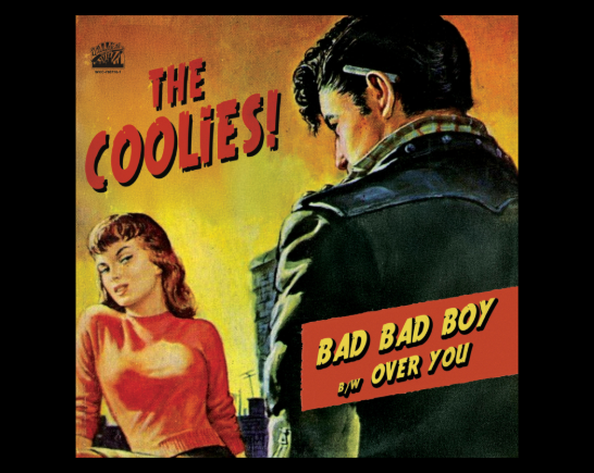 Over the shoulder of a boy in a leather jacket with a black 50's style pompodor hair style, cigarette behind his ear and a pretty girl in a red sweater with red hair gives him a suspicious side eye look.