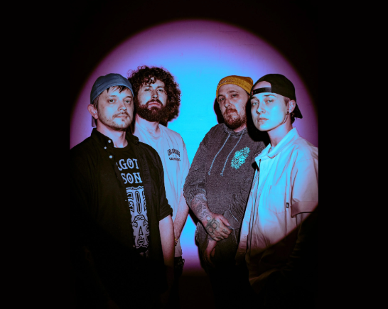 Pop Punk band GOLDSTATE in a blue spotlight in front of a black backdrop