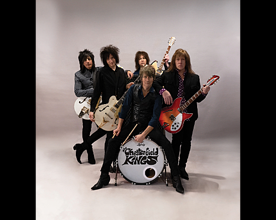 The Chesterfield Kings 5 rock n roll musicians hold electric guitars and stand next to a kick drum