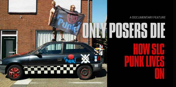 Two young punk rockers hold up a banner that says PUNK as they stand on top of a black hatchback car with black and white checker pattern