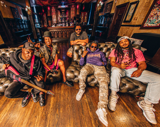 Five members of the ska punk funk band Fishbone pose in a very cool living room