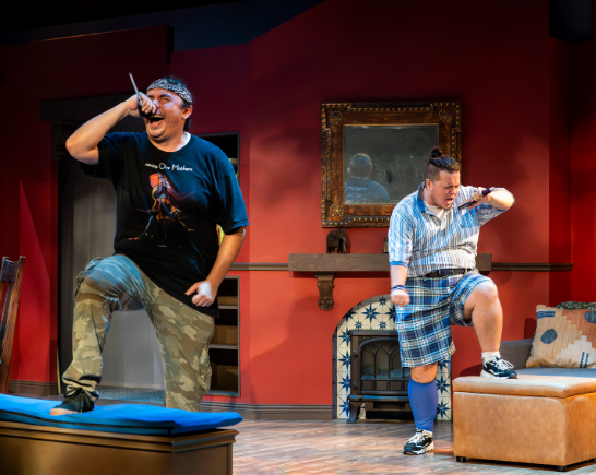Two actors perform on a living room set. They do a raucous version of a song