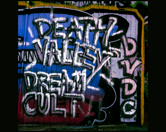 Graffiti covered wall that says Death Valley Dream Cult