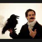 Lit-hop artist MC LARS wears a cravat and holds a stuffed raven and a long white quill