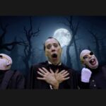 Three Vampires beneath the full moon with dark bare trees in the background