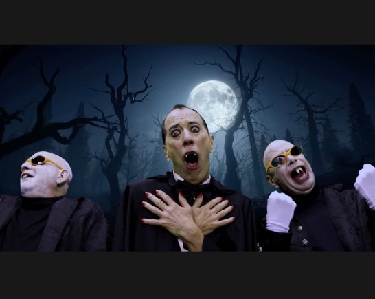Three Vampires beneath the full moon with dark bare trees in the background