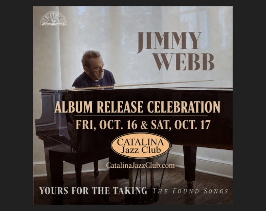 Songwriter Jimmy Webb sits at a grand piano in front of a window with sunlight streaming in.